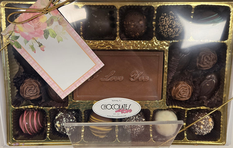 An I Love You chocolate bar surrounded by truffles in a gold box